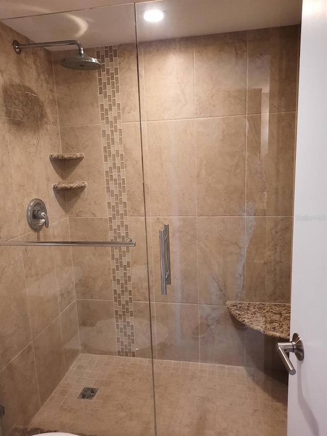 bathroom with a shower with door