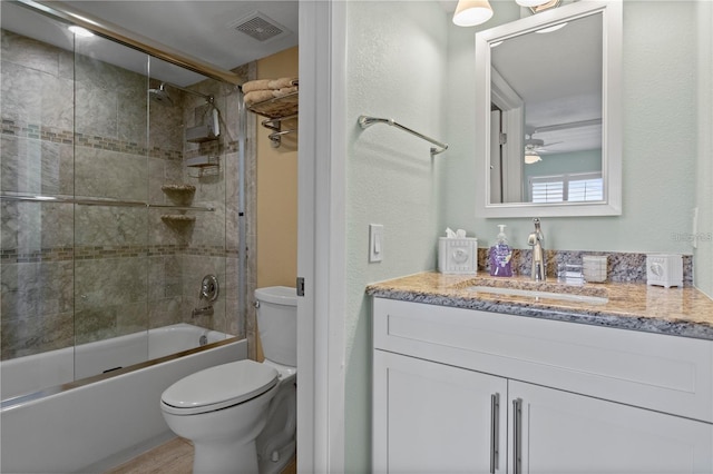 full bathroom with shower / bath combination with glass door, vanity, toilet, and ceiling fan