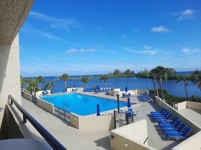 view of swimming pool with a water view and a patio