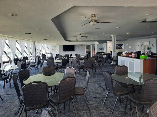 dining space with dark colored carpet, ceiling fan, and a textured ceiling