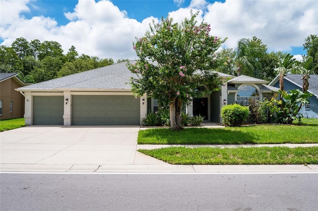 view of front of property with a garage and a front lawn