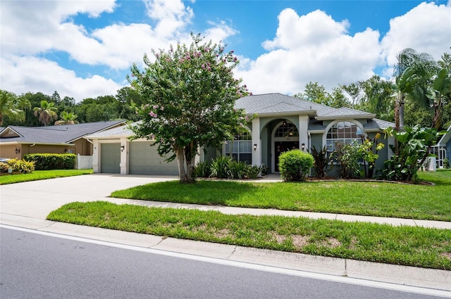 single story home with a garage and a front lawn