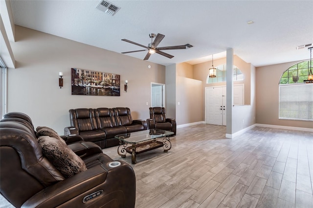 living room with a textured ceiling and ceiling fan