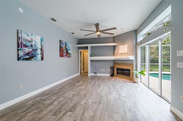 unfurnished living room featuring ceiling fan, wood-type flooring, and a textured ceiling