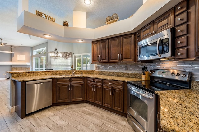 kitchen with dark brown cabinets, sink, appliances with stainless steel finishes, and tasteful backsplash