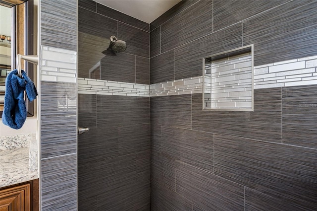 bathroom featuring vanity and tiled shower