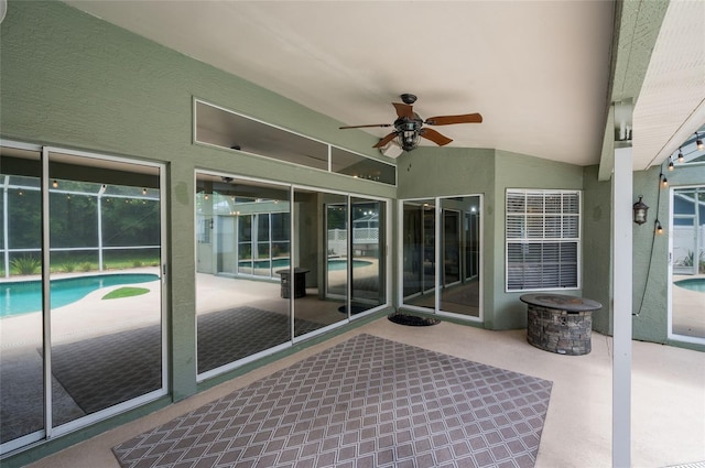 unfurnished sunroom with ceiling fan and vaulted ceiling