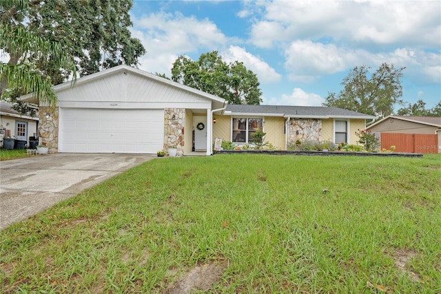 single story home featuring a garage and a front lawn