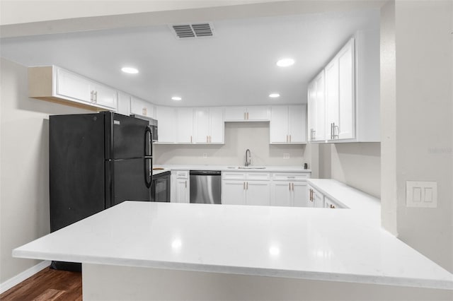 kitchen featuring dishwasher, kitchen peninsula, and white cabinetry