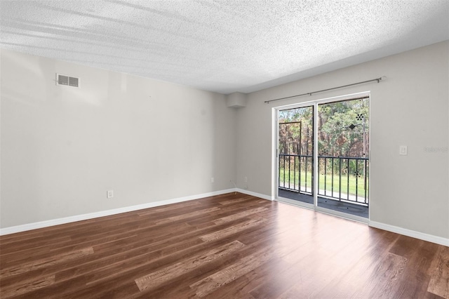 unfurnished room featuring a textured ceiling and dark hardwood / wood-style floors