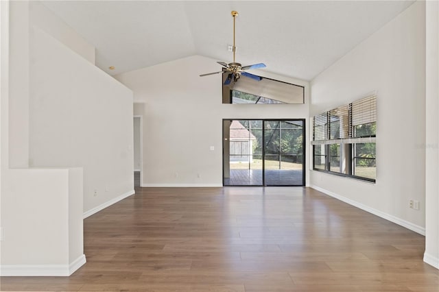 empty room with hardwood / wood-style floors, high vaulted ceiling, and ceiling fan