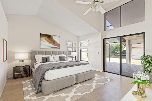 bedroom featuring multiple windows, high vaulted ceiling, access to exterior, and light wood-type flooring