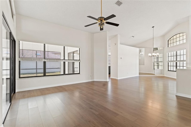 unfurnished living room featuring hardwood / wood-style flooring, ceiling fan with notable chandelier, a textured ceiling, and high vaulted ceiling