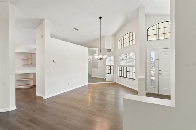 entrance foyer with an inviting chandelier, dark hardwood / wood-style flooring, high vaulted ceiling, and a textured ceiling