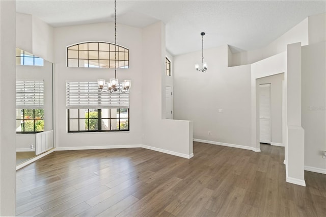 interior space featuring a healthy amount of sunlight, hardwood / wood-style floors, and a notable chandelier