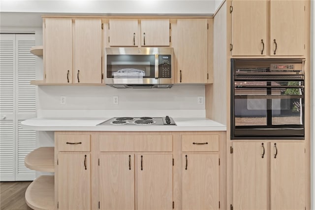 kitchen with light brown cabinetry, hardwood / wood-style floors, oven, and white electric stovetop