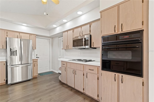 kitchen featuring stainless steel appliances, ceiling fan, light brown cabinets, and light hardwood / wood-style floors