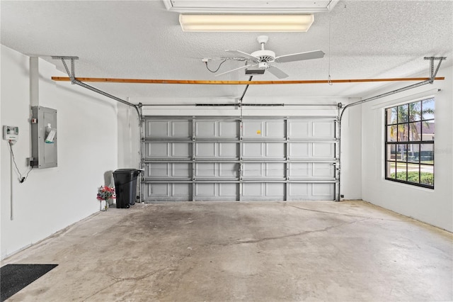 garage featuring a garage door opener, electric panel, and ceiling fan