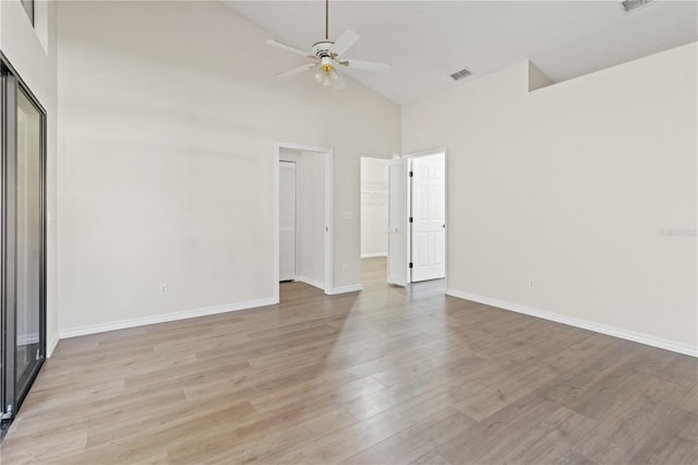 unfurnished bedroom with ceiling fan, high vaulted ceiling, light wood-type flooring, and a closet