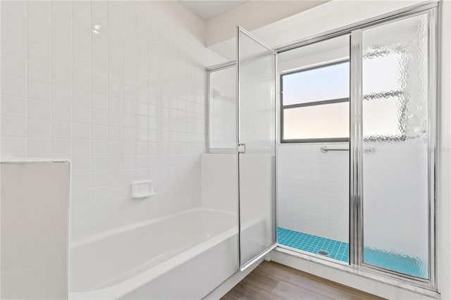 bathroom featuring wood-type flooring and independent shower and bath