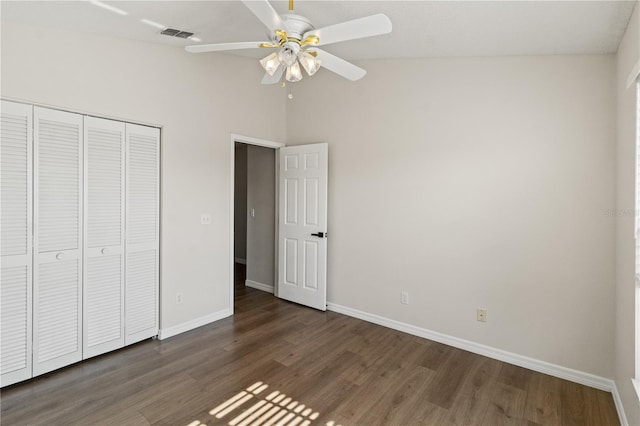 unfurnished bedroom featuring dark wood-type flooring, ceiling fan, vaulted ceiling, and a closet