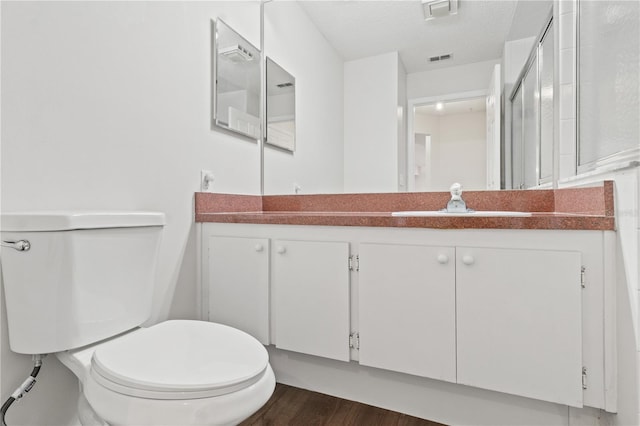 bathroom featuring hardwood / wood-style flooring, vanity, a textured ceiling, and toilet