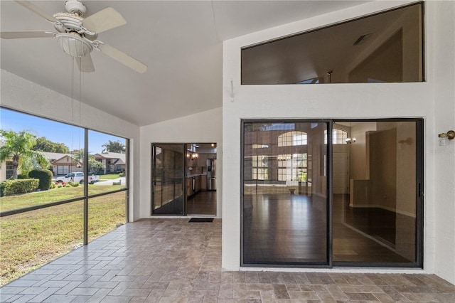 unfurnished sunroom with vaulted ceiling and ceiling fan