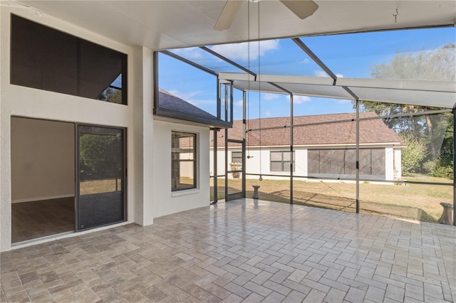 unfurnished sunroom featuring ceiling fan