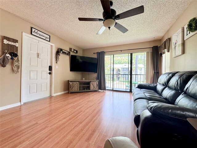 living room with hardwood / wood-style floors, a textured ceiling, and ceiling fan