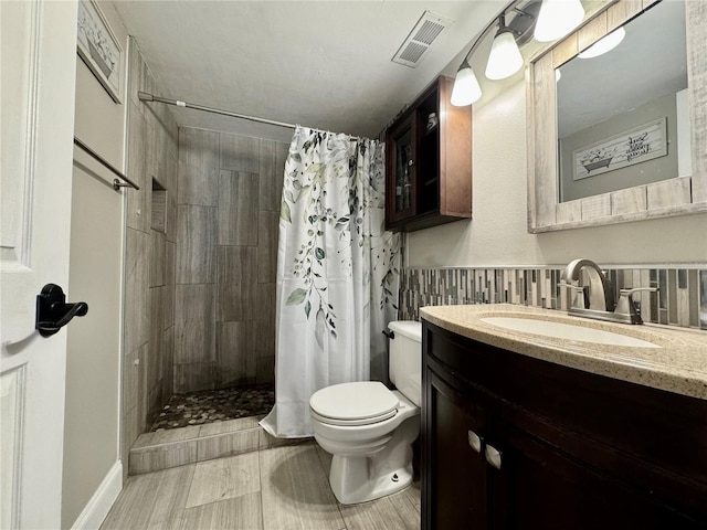 bathroom featuring vanity, toilet, and walk in shower