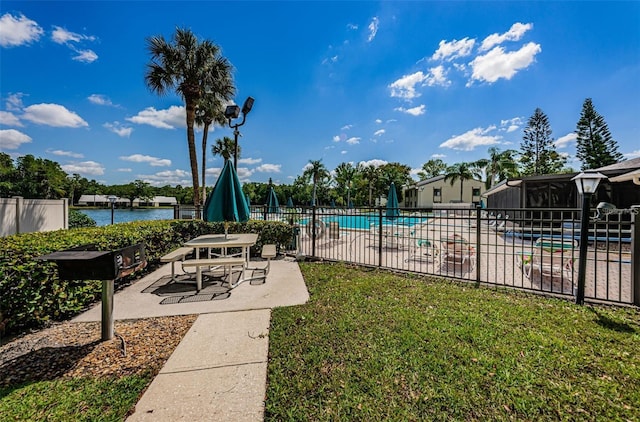 view of swimming pool with a yard, a water view, and a patio