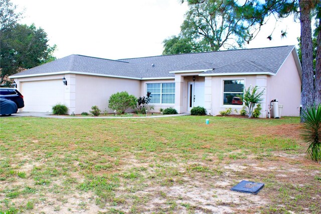 single story home with a garage and a front lawn