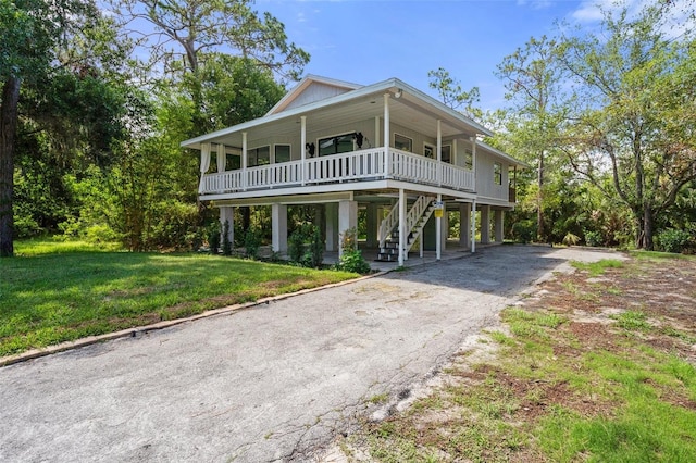 coastal inspired home with covered porch, a carport, and a front yard