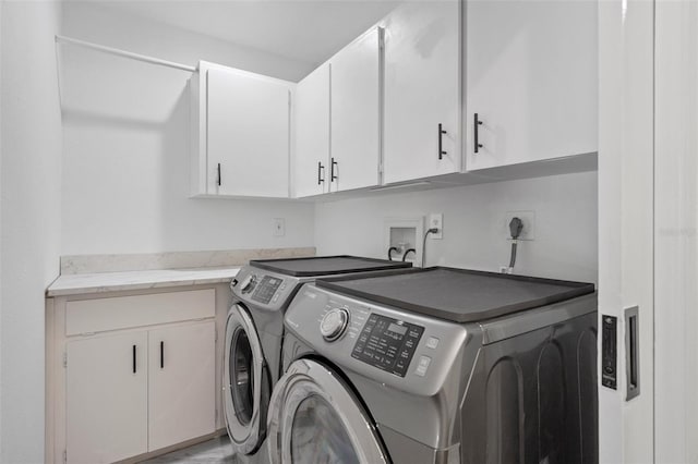 laundry room featuring cabinets and washer and clothes dryer