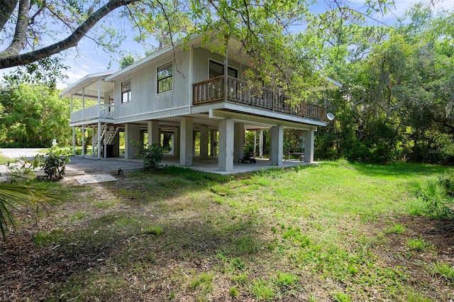 back of property with a yard and a balcony