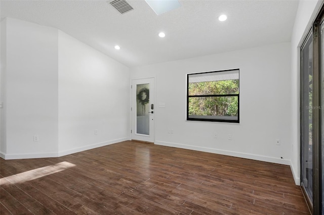 unfurnished room featuring a textured ceiling, dark hardwood / wood-style floors, and lofted ceiling