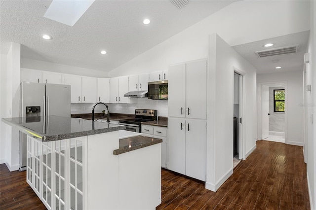 kitchen featuring appliances with stainless steel finishes, dark hardwood / wood-style flooring, a textured ceiling, lofted ceiling with skylight, and white cabinets