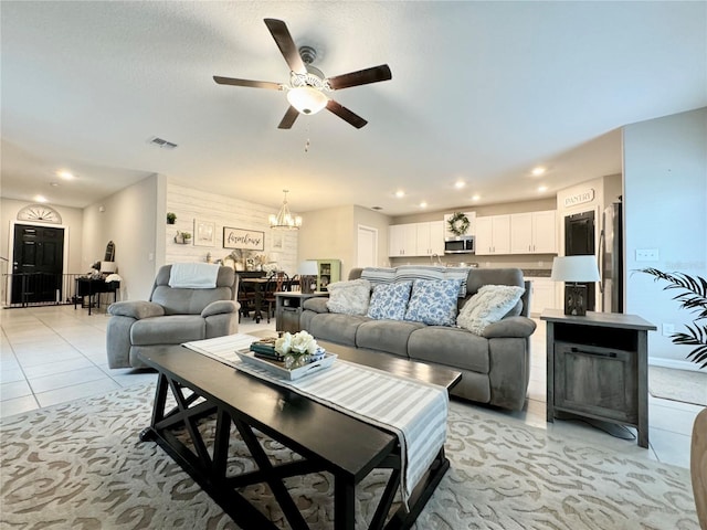 living room featuring light tile patterned floors and ceiling fan with notable chandelier