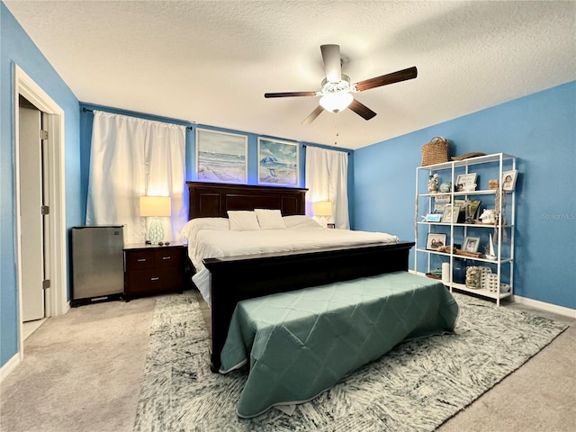 bedroom featuring light colored carpet, a textured ceiling, and ceiling fan