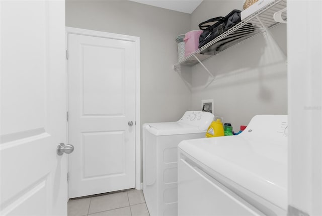 laundry area with light tile patterned flooring and independent washer and dryer