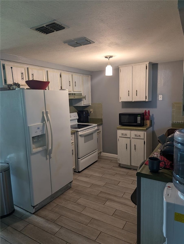 kitchen with pendant lighting, wood-type flooring, white appliances, and a textured ceiling