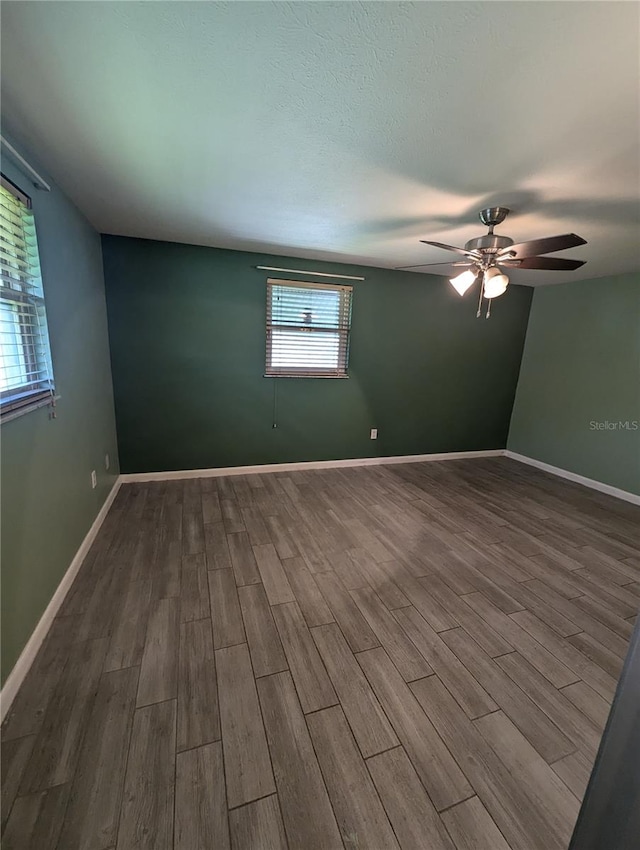 unfurnished room featuring wood-type flooring, a wealth of natural light, and ceiling fan