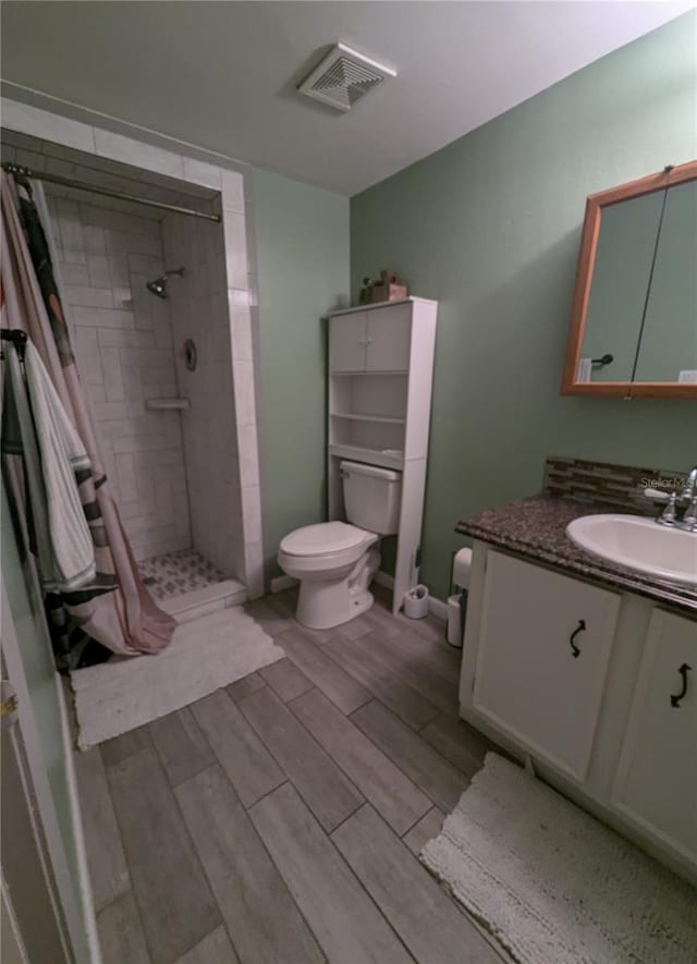 bathroom with toilet, vanity, and a shower with shower curtain