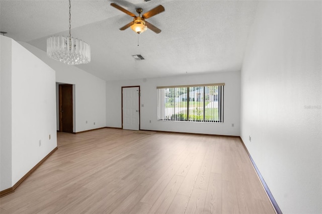 unfurnished living room featuring ceiling fan with notable chandelier, light hardwood / wood-style floors, lofted ceiling, and a textured ceiling