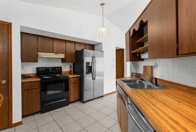 kitchen featuring pendant lighting, sink, vaulted ceiling, light tile patterned floors, and appliances with stainless steel finishes