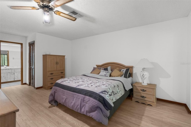 bedroom featuring light hardwood / wood-style flooring, ensuite bath, ceiling fan, a textured ceiling, and a closet