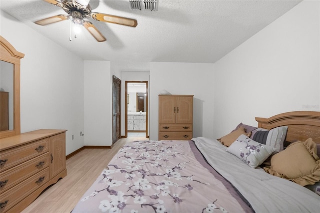 bedroom featuring ceiling fan, ensuite bathroom, a textured ceiling, a closet, and light wood-type flooring