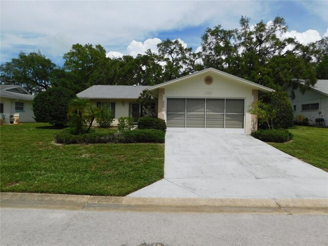 ranch-style house with a garage and a front lawn