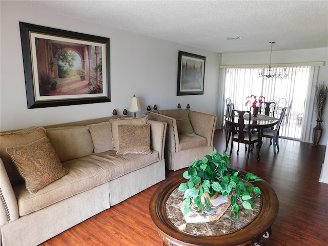 living room featuring hardwood / wood-style floors, an inviting chandelier, and a textured ceiling