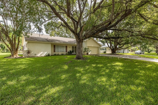 ranch-style home featuring a garage and a front yard